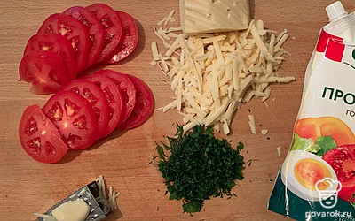 Помидор нарезать кольцами толщиной 3-4 миллиметра. Чеснок натереть на мелкой терке, зелень мелко порубить, сыр натереть на крупной терке.