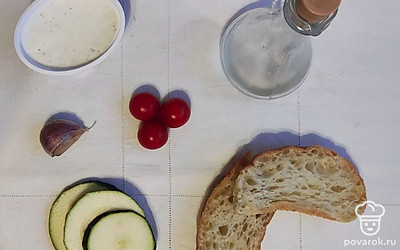 Подготовьте ингредиенты. Разогрейте сковородку, очистите чеснок. Кабачок нарежьте кольцами и очистите от кожуры. 