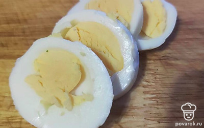 Яйцо нарежьте кружками. Выложите яйцо на сыр и сверху поместите шпроты.