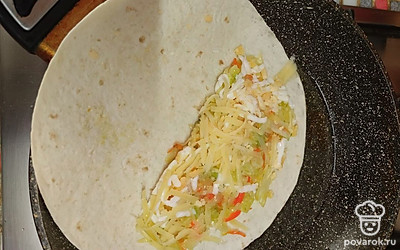 На один край выложить сначала сыр, затем тушеную капусту с морковью и яйцом, затем опять сыр.