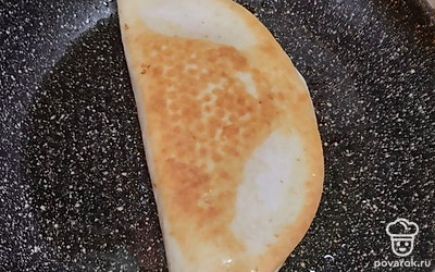 Завернуть лепёшку и жарить на разогретой сковороде с двух сторон на небольшом количестве растительного масла.