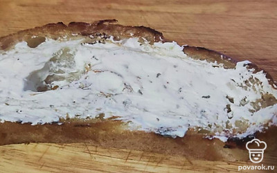 Натрите хлеб с обеих сторон чесноком и намажьте творожным сыром.