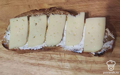 Сверху разложите сыр, а затем полоски колбасы.