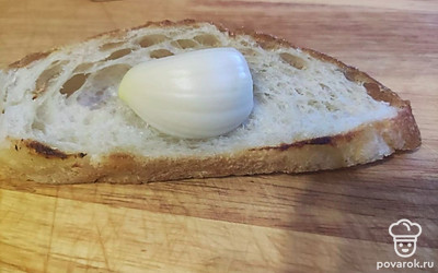 Натрите хлеб с двух сторон чесноком.