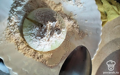 Достаем лук из воды и отправляем в сухую панировку. Хорошо расправляем лук, обсыпаем.