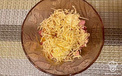 Посыпьте тертым сыром и опять перемешайте.