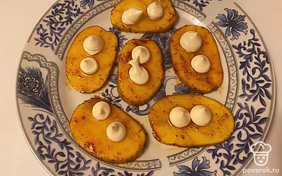 Выложите картошку на плоской и большой тарелке, смажьте каждый ломтик майонезом.