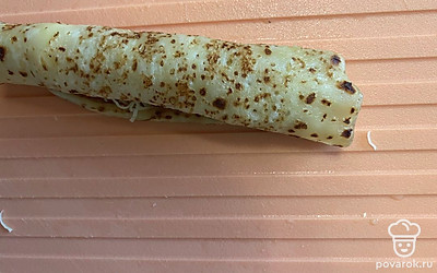 Из блина скрутите рулетик и порежьте на части.