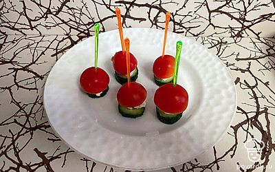 Сверху уложите сыр небольшим кубиком и половинку помидорки черри. Закрепите с помощью шпажки.