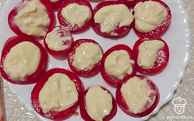 Намазываем помидоры майонезом с чесноком, сверху посыпаем сыром.