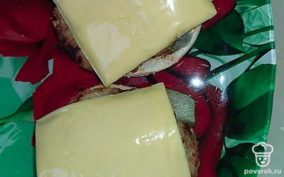 Поверх огурца кладем котлету. Если вы любите сыр, можно выложить его на горячую котлету, чтобы он расплавился. Я иногда использую специальный сыр для гамбургеров.