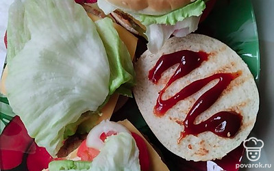 На котлеты или сыр укладываем салат айсберг и помидор. Накрываем верхней булочкой. Также для остроты добавляем кольца лука. Бургеры готовы! 