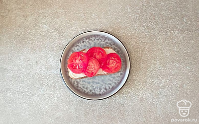 Сверху выложите нарезанный помидор и слегка посолите.