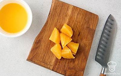 Разрежьте апельсин пополам. Выжмите из одной половины сок. Очистите вторую половину от кожуры, разделите ее на дольки и снимите с них кожицу. 