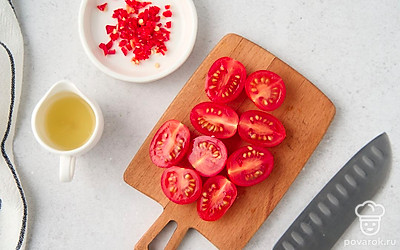 Отрежьте от лимона ¼ часть, выжмите из нее сок. Разрежьте пополам помидоры черри. Мелко порубите перец чили. 