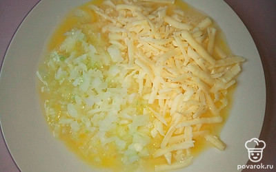 Добавьте тертый сыр и мелко накрошенный лук во взбитые яйца с солью и хорошо перемешайте. 