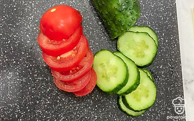 Режем ломтиками помидор и огурец.