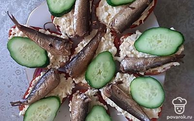 К шпротам выложите огурец. 