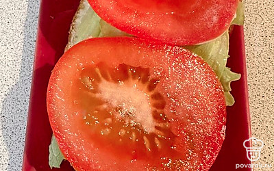 Поверх листа кладем ломтики нарезанного кружочками помидора.