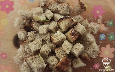 Хлеб нарежьте кубиками, перемешайте с маслом и чесноком.