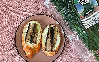 Положите сверху шпроты.