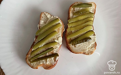 Смажьте хлеб майонезом, сверху выложите полоски огурца.