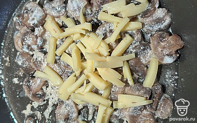 К обжаренным шампиньонам добавляем мелко нарезанный сыр. Выключаем плиту.