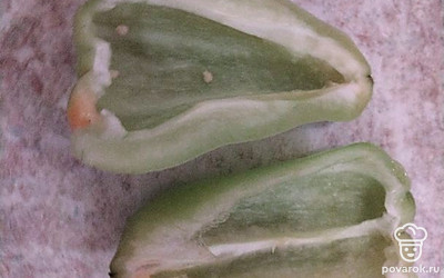 Перец очистить от плодоножки, стенок и семян. Разрезать вдоль на половинки.