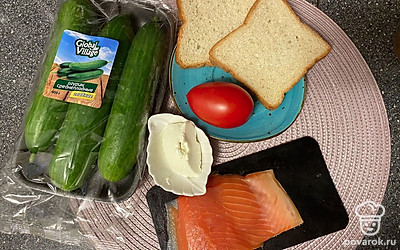 Подготовьте все ингредиенты. Огурец и помидор помойте и нарежьте тонкими пластинками, хлеб обжарьте в тостере или на сковороде без масла. Рыбу нарежьте тонкими пластинами.