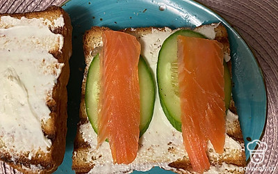 На огурец выложите кусочки рыбы. Сверху положите помидор.