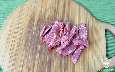 Копченую колбасу нарезать соломкой. 