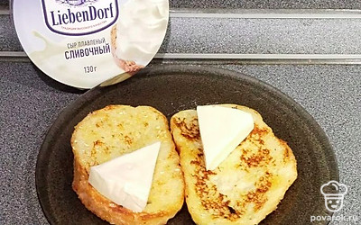 Положить на каждый ломтик треугольник плавленого сыра.