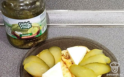 Рядом с сыром выложить кусочки соленого огурца.