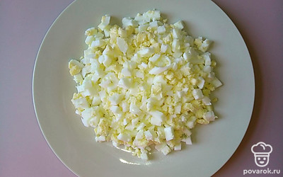 Отварите до готовности и остудите куриные яйца. Очистите их и нарежьте небольшими кубиками.