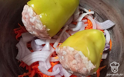На дно кастрюли выложите половину нарезанных овощей. Сверху положите перцы.