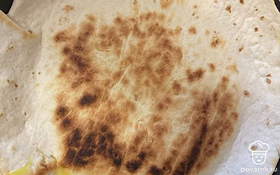 Сразу же накрыть омлет лавашом и прижать. Можно накрыть крышкой и дать обжариться.