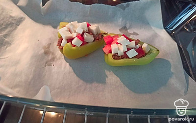 Перец разрезаем на две половинки, выкладываем в него обжаренный фарш, помидор и сыр. Ставим в разогретую до 180 градусов духовку на 15 минут. 