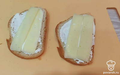 Два ломтика хлеба смазываем сметаной, выкладываем сыр. 
