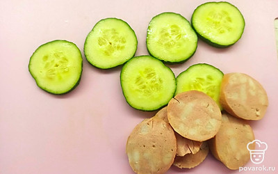 Колбасу и огурец нарежьте кольцами.