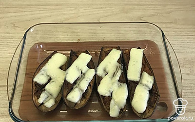 Достать, выложить на каждый баклажан сыр, снова поставить в духовку до расплавления сыра.