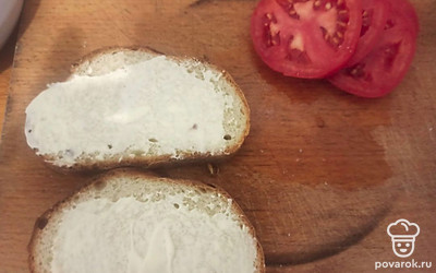 Намажьте тосты сметаной, помидор нарежьте кольцами.