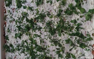 Остывший корж смазать творожной смесью, посыпать зеленью.