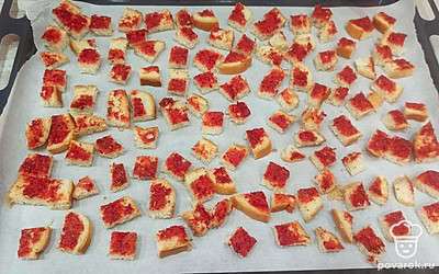 Нарезаем хлеб небольшими кубиками. Выкладываем на противень, застеленный пергаментной бумагой, и ставим в духовку, разогретую до 180 градусов, на 15 минут. 