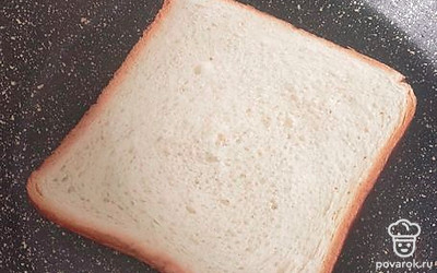 На разогретую сковороду положить кусочек хлеба. У меня сковородка с антипригарным покрытием, поэтому масло я не добавляю. Вы же можете смазать сковороду маслом. 