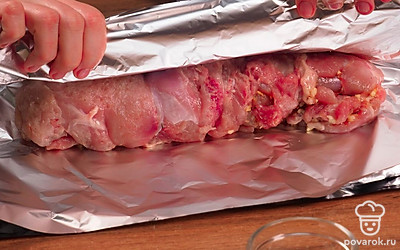Сделайте рулет. Сложите отбивные рядом внахлест так, чтобы получился один пласт. Посыпьте его солью, специями, паприкой. Выложите кусочки чеснока. Сверху разместите кусочки сала. По одному краю мясного пласта разместите 5 брусочков моркови. Плотно сверните рулет. Выложите его на пергамент для запекания. Заверните говяжий рулет в пергамент и завяжите края нитками.