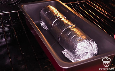 Запеките рулет. Выложите рулет на противень и поставьте в духовку. Запекайте 60 минут.