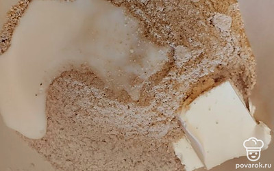 Затем добавить в крошку мягкое сливочное масло и сгущенное молоко, полпачки. Размешать до однородной массы. Можно добавить в тесто какао, чтобы придать рулету шоколадный вкус.