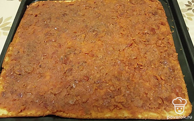 Пока корж не остыл, переложите его на другой лист, распределите начинку и сверните в рулет. 