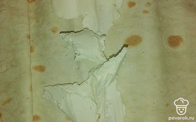 Расстелить лаваш на разделочной доске. Выложить сыр. 