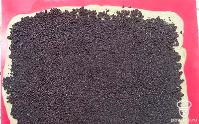 Через 40 минут тесто раскатать в виде прямоугольника с толщиной несколько миллиметров. Выложить маковую начинку на тесто.